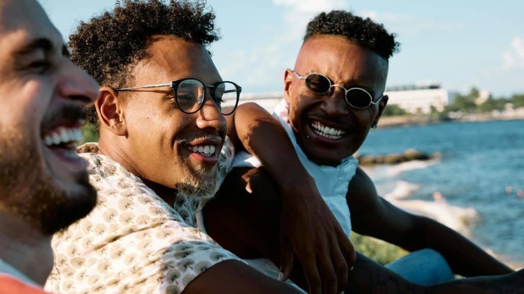 A group of friends laughing by the water.