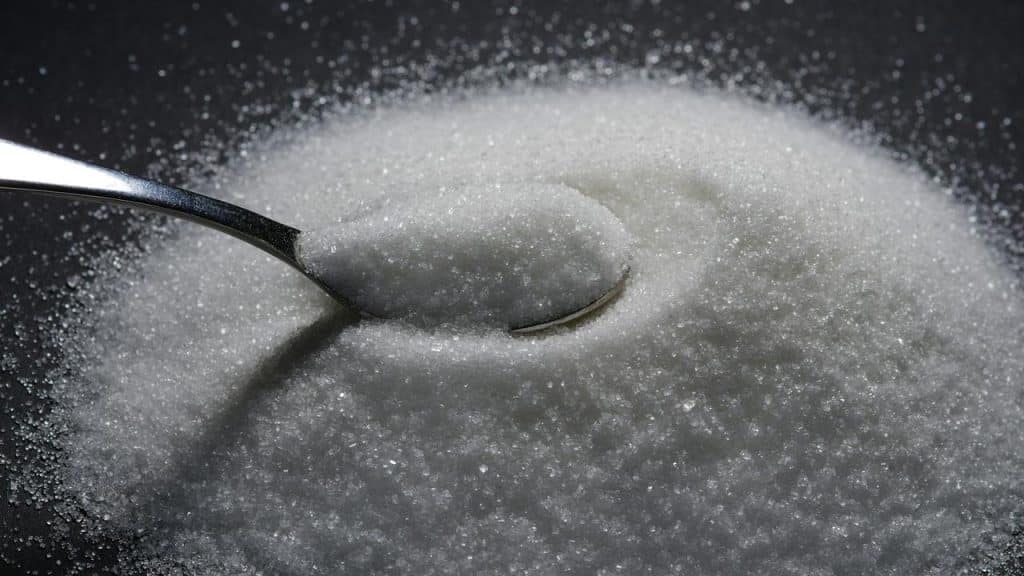 A spoonful of white granulated sugar.