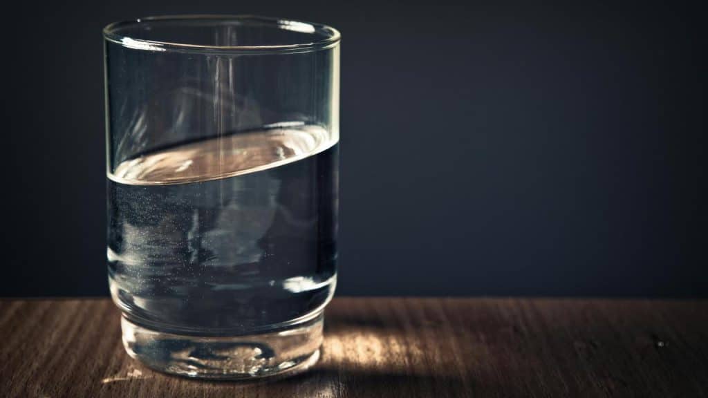 A glass of water on a wooden table.