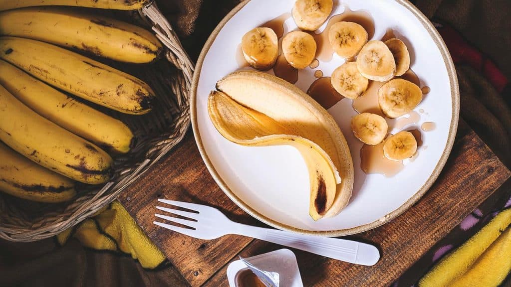 A plate of sliced bananas with syrup.