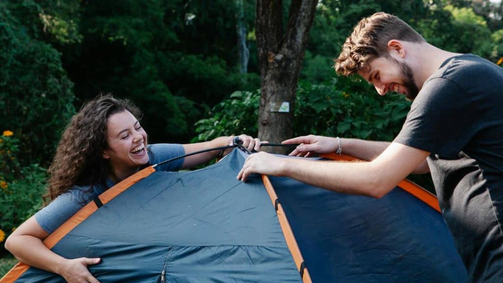 A couple putting up a tent.