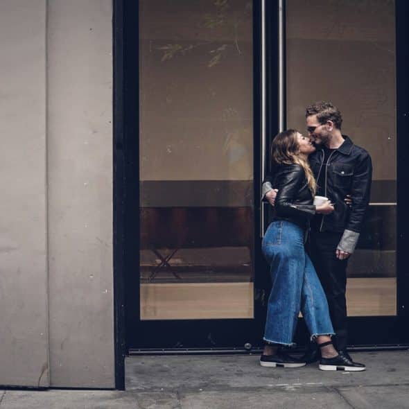 A couple kissing outdoors.