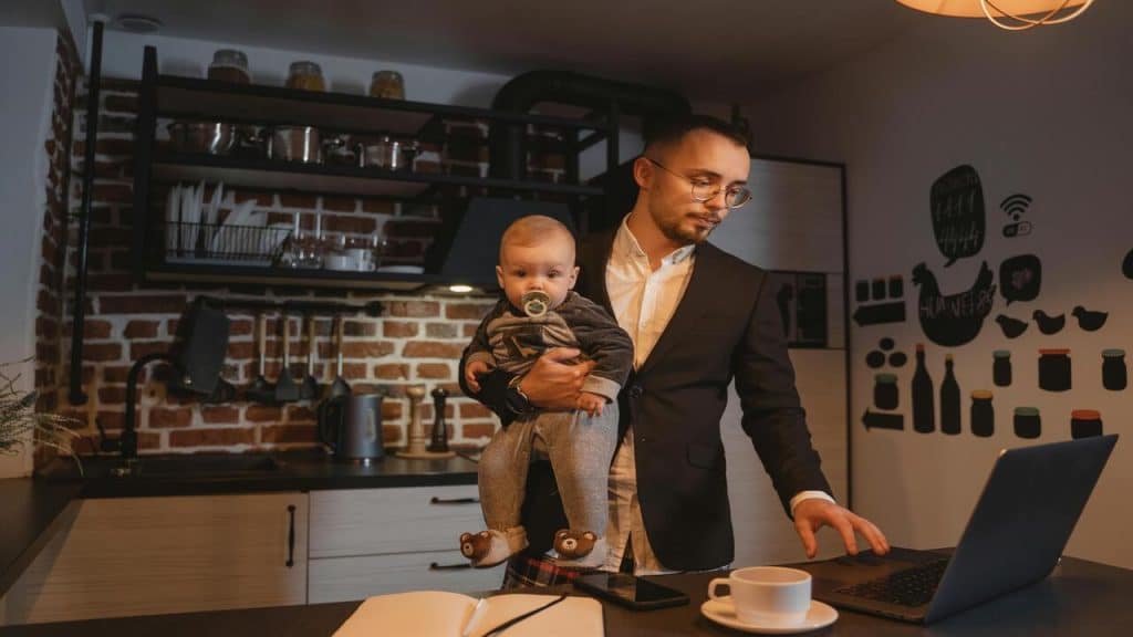 A man working while taking care of his baby.