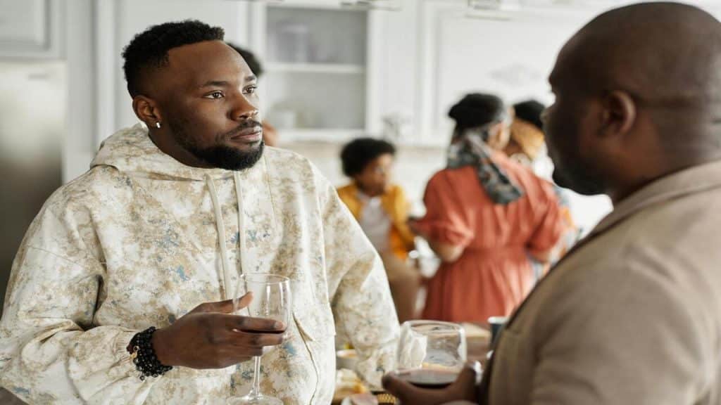 A man talking to his friend at a party.
