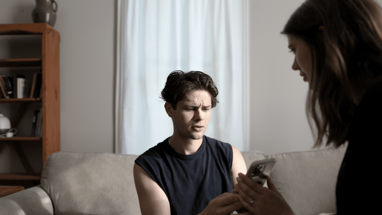 A man looking at his girlfriend’s phone.