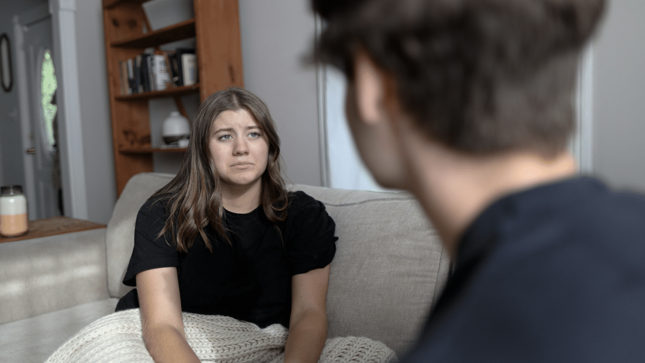 A woman asking her boyfriend not to leave.