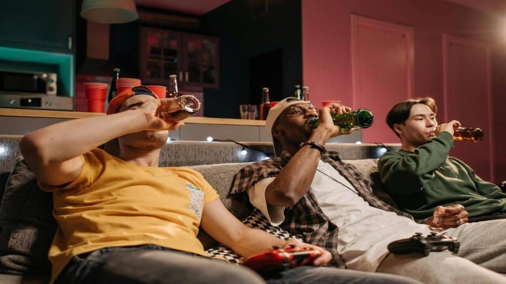 Friends having beer and playing video games.
