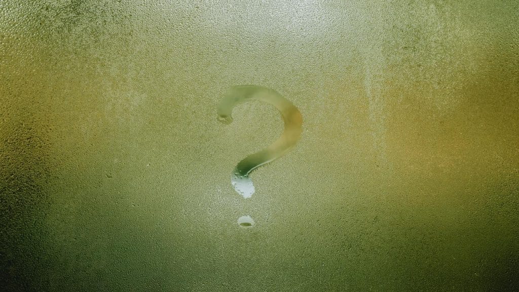 A question mark on a misted window.