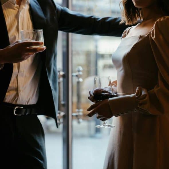 A man and a woman holding glasses.