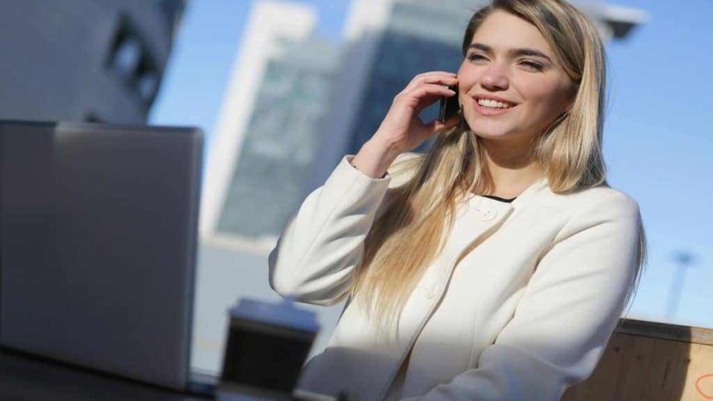 A woman smiling while working outdoors.