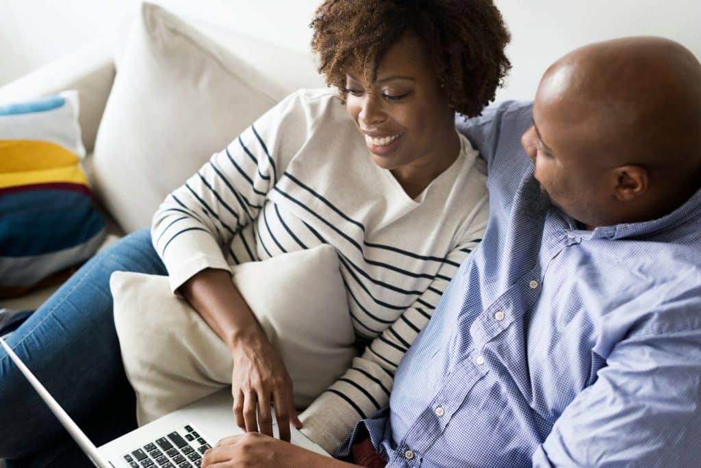 A woman looking at the laptop while a man looking at her.