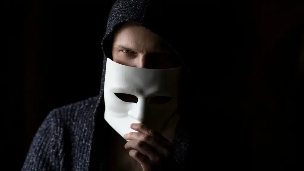 A man about to remove his mask