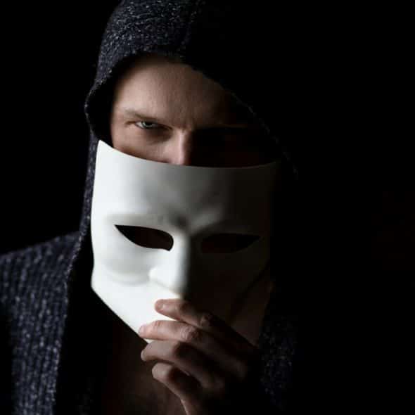 A man about to remove his mask