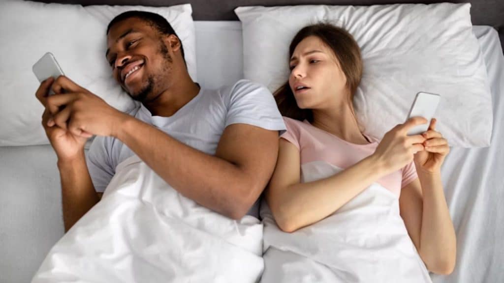 Man looking at his phone while partner peers over his shoulder