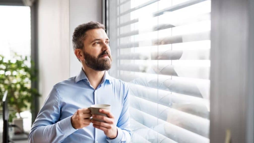 Man staring out a window deep in thought