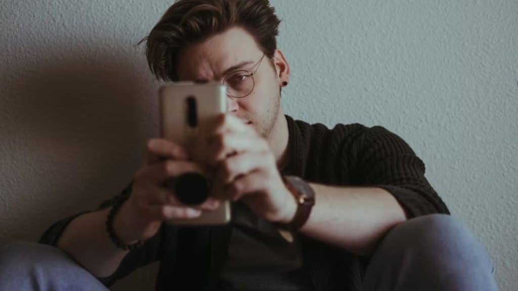 Man staring at old photos on his phone