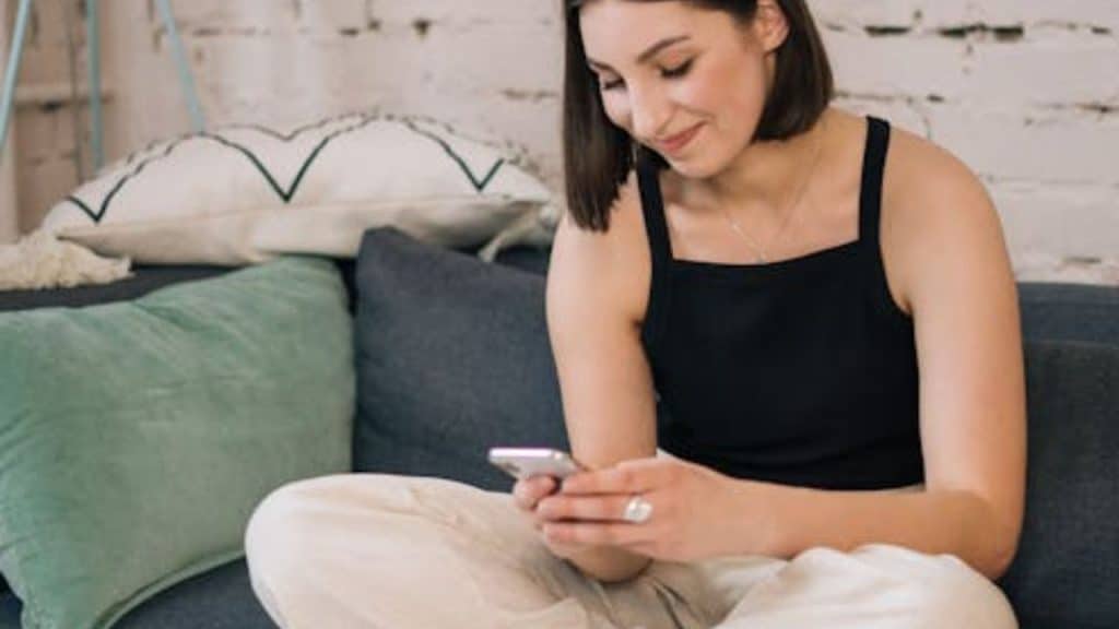 Woman smiling while reading a thoughtful message on her phone Image.