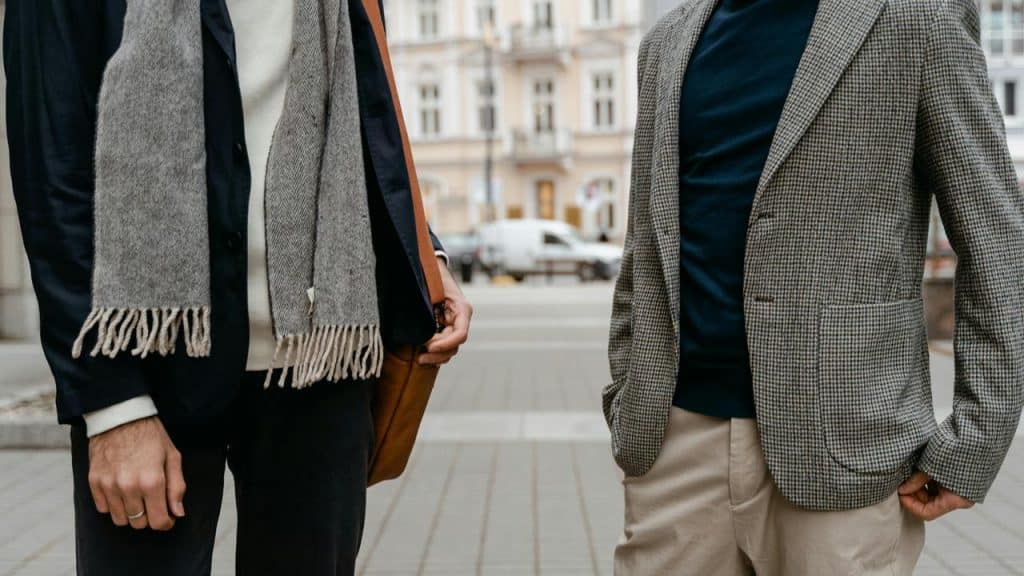 A pair of men standing and chatting on a city sidewalk.