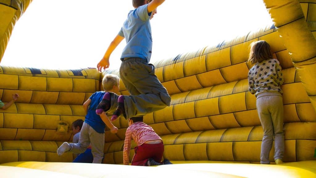 A group of kids playing in a yellow bounce house.