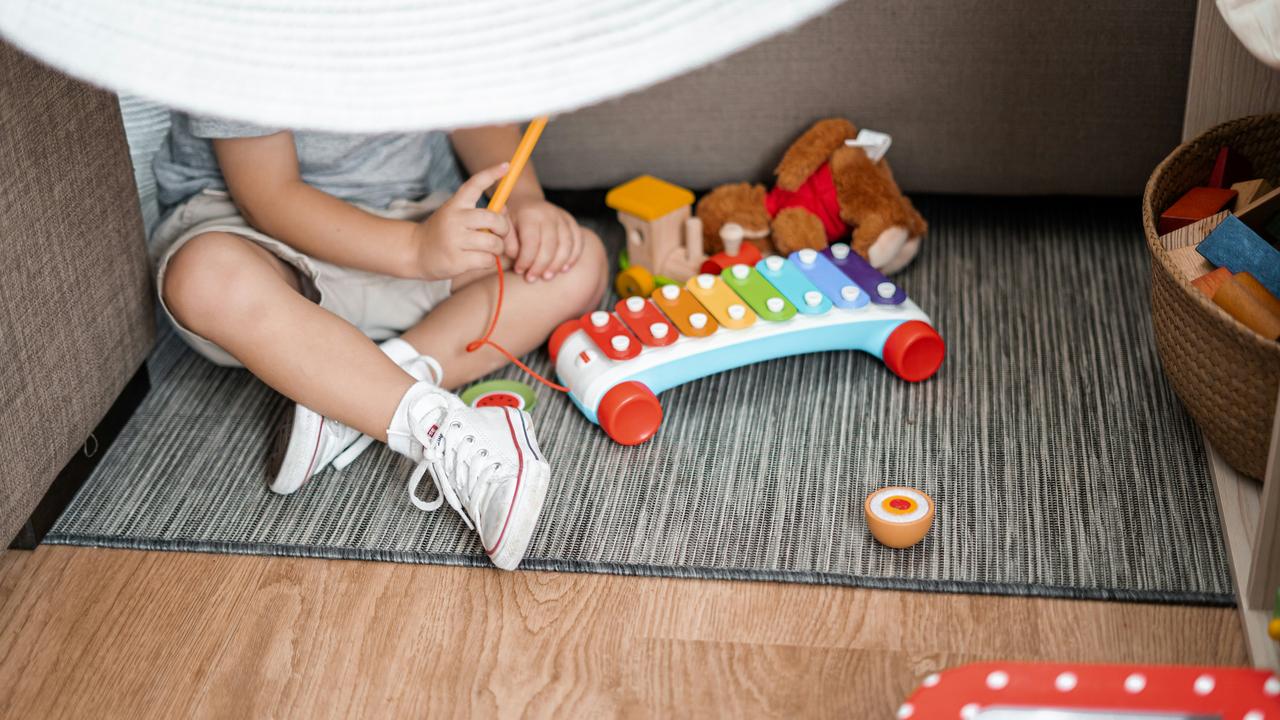 A child playing with a colorful xylophone.