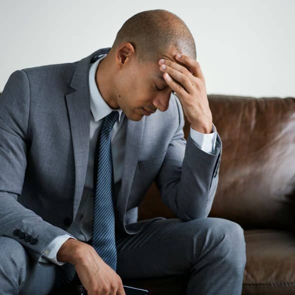 A man holding head because of headache.