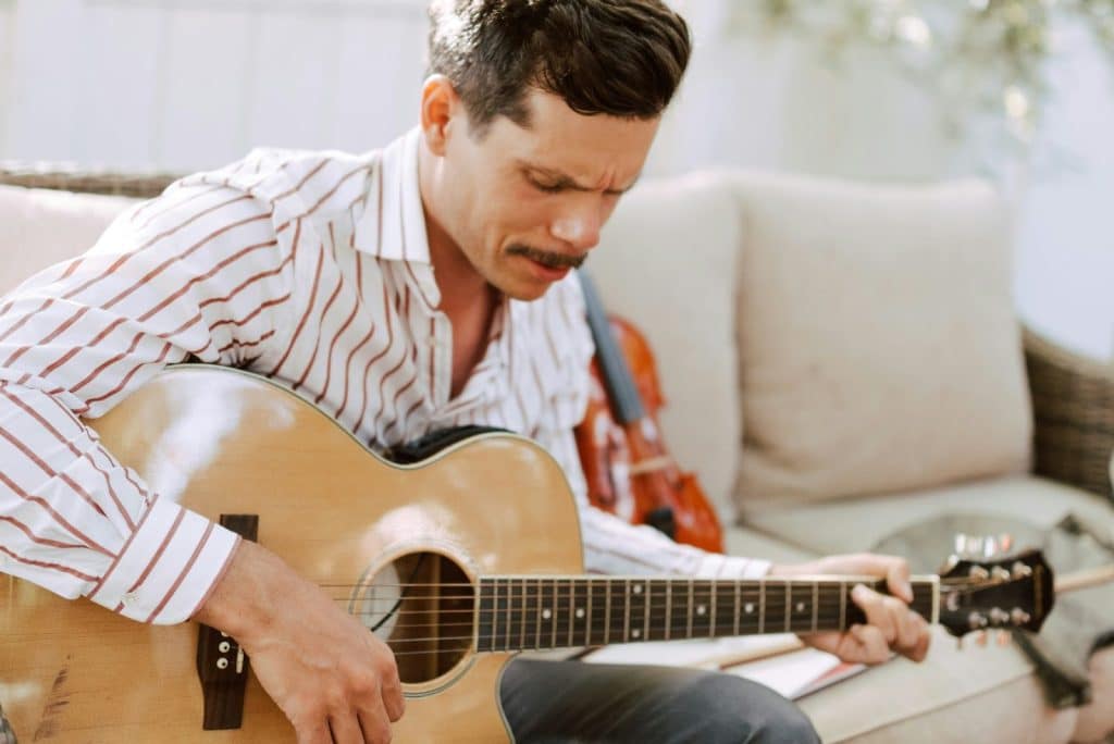 A man learning how to play a guitar