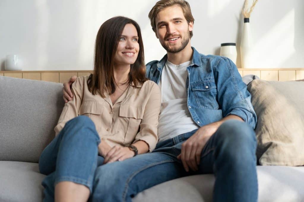 A picture of a happy  couple sitting at the couch