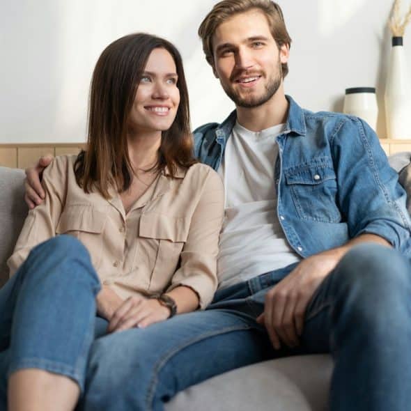 A picture of a happy couple sitting at the couch