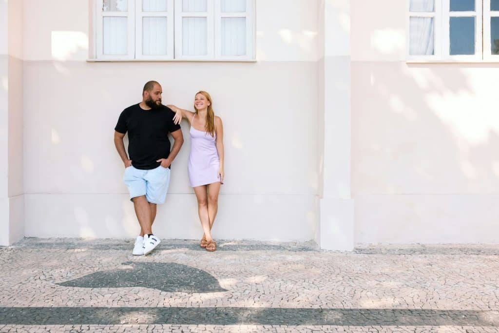 A woman resting her arms on a man’s shoulder