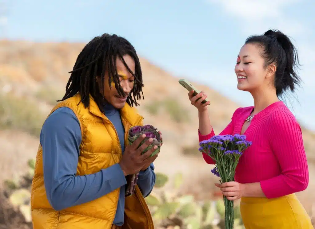 A couple taking a picture of the flowers 