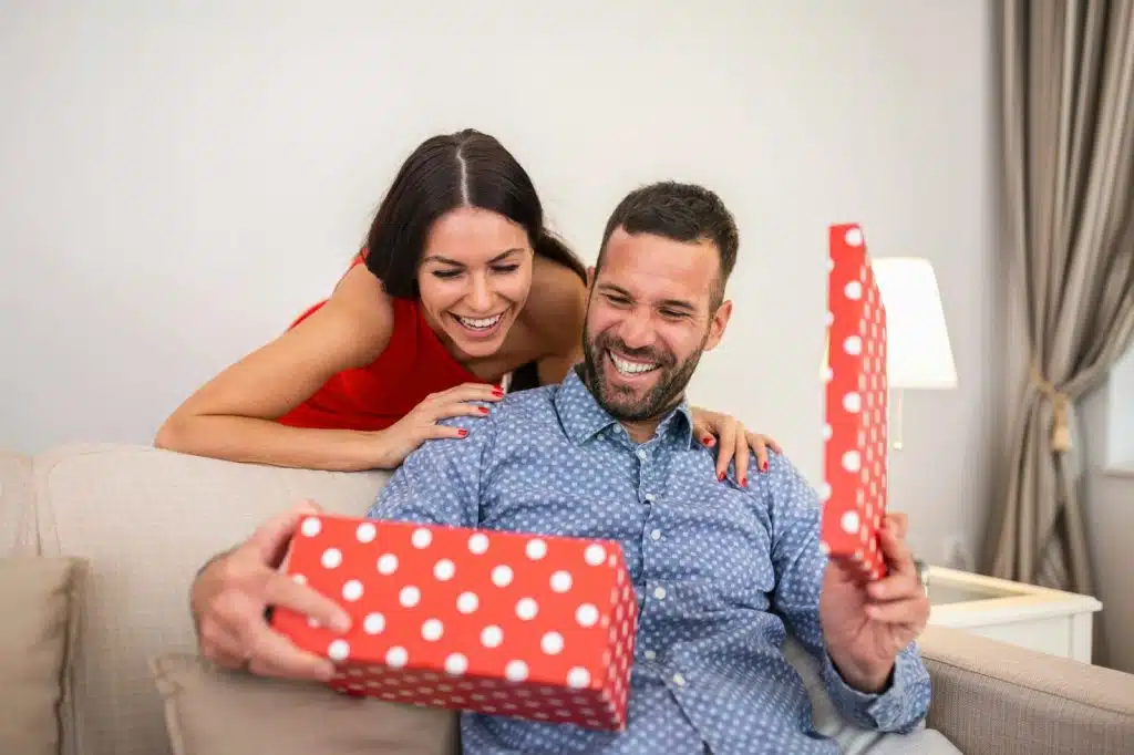 A woman giving a gift to a man