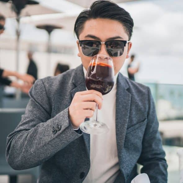 A man drinking a wine as a celebration of winning