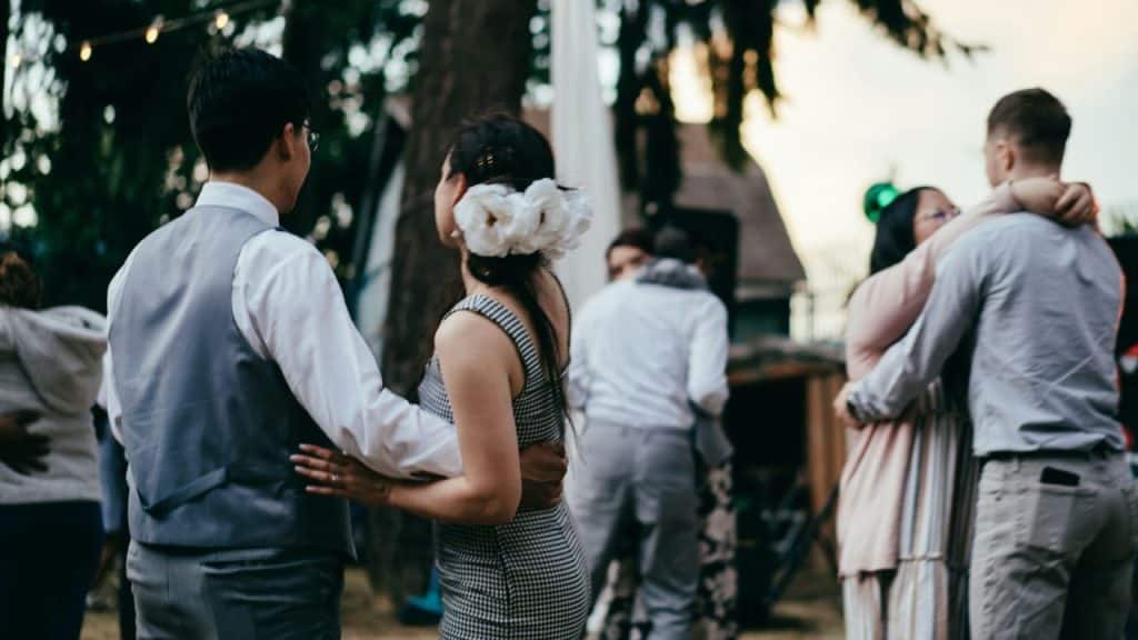 A man and a woman dancing together in a dimly lit outdoor space.