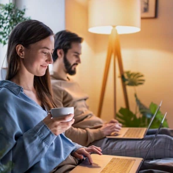Couple appearing emotionally distant while sitting together at home