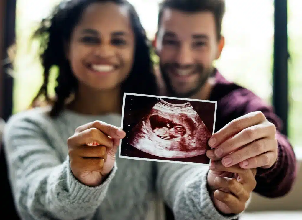 A man and woman holding a sonogram