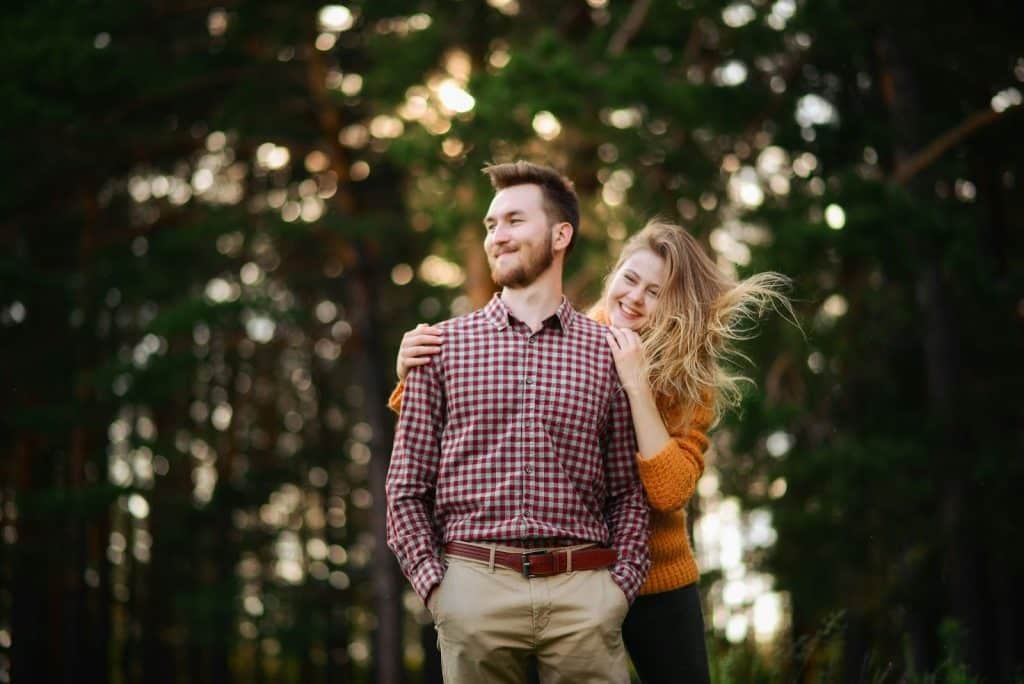 A woman hugging a man from behind.