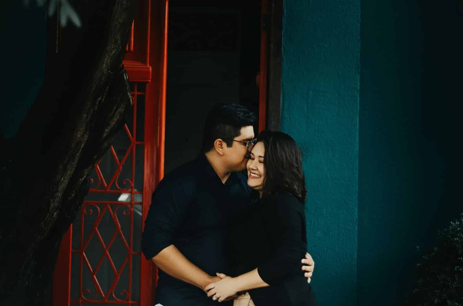 A man kissing a woman’s cheek.