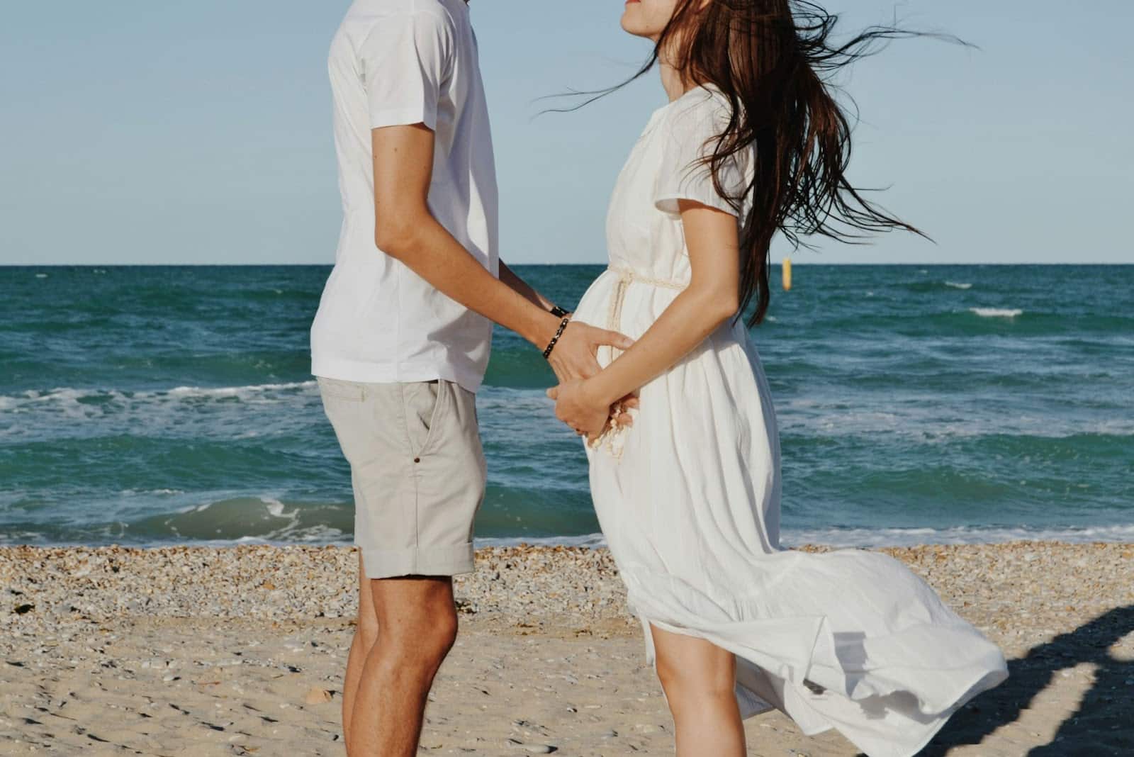 A man holding a woman’s belly.