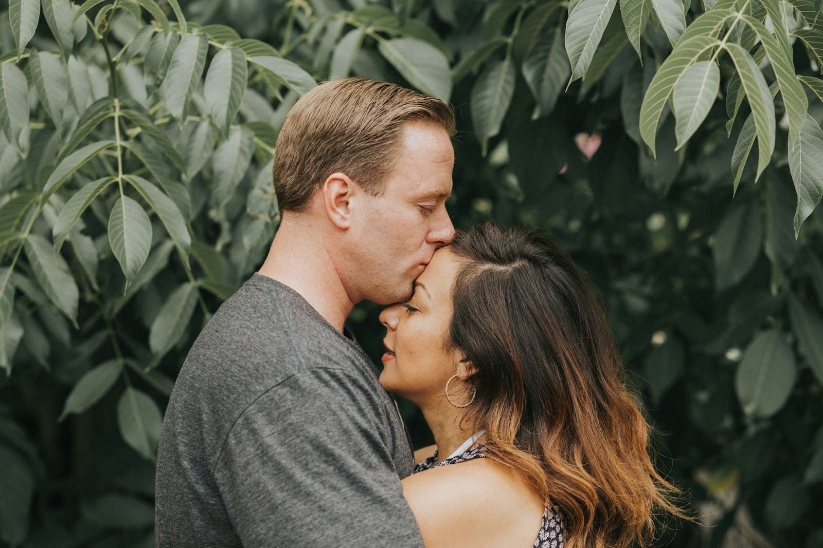 A man kissing a woman’s forehead.