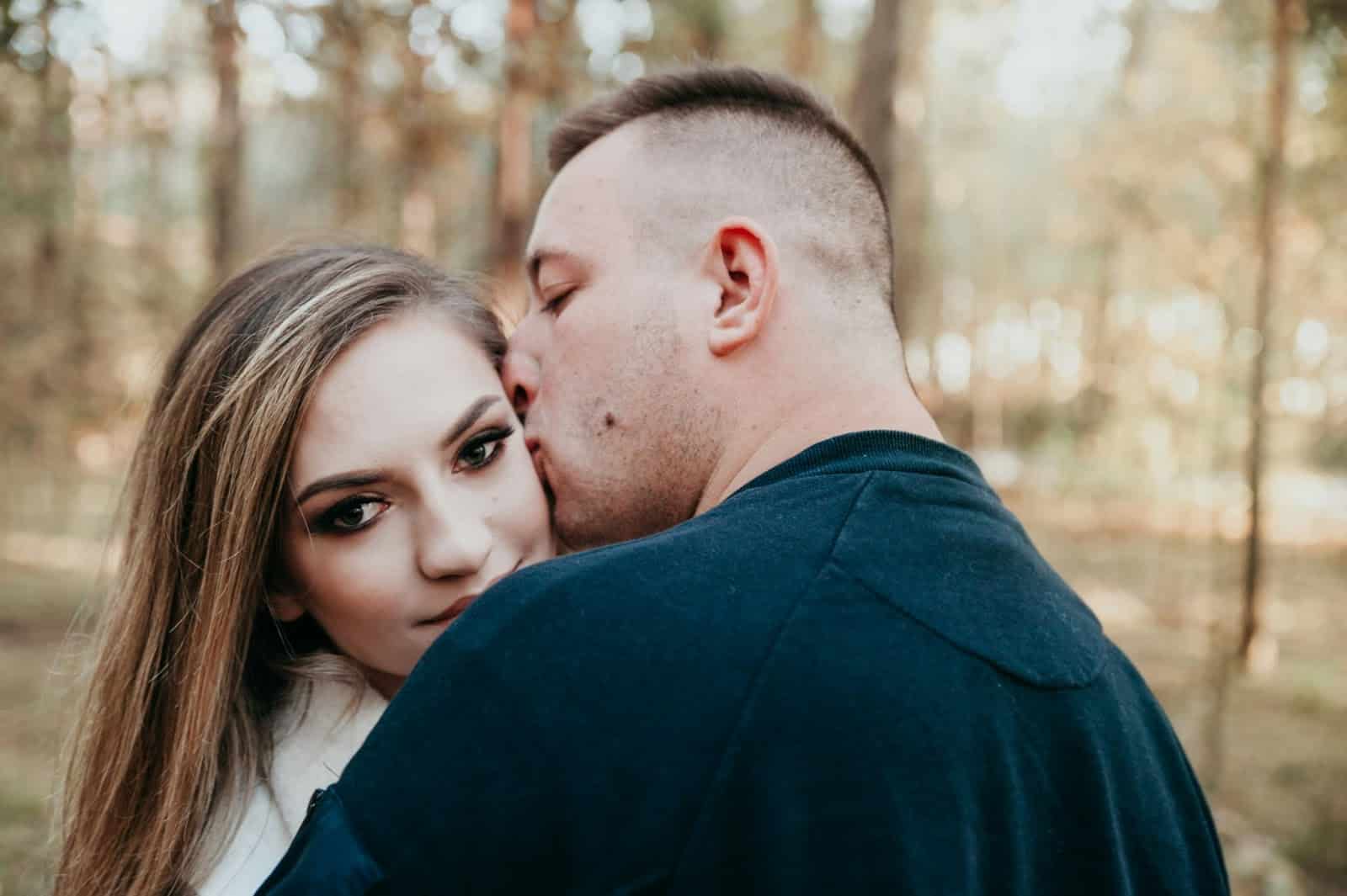A man kissing a woman’s cheek.