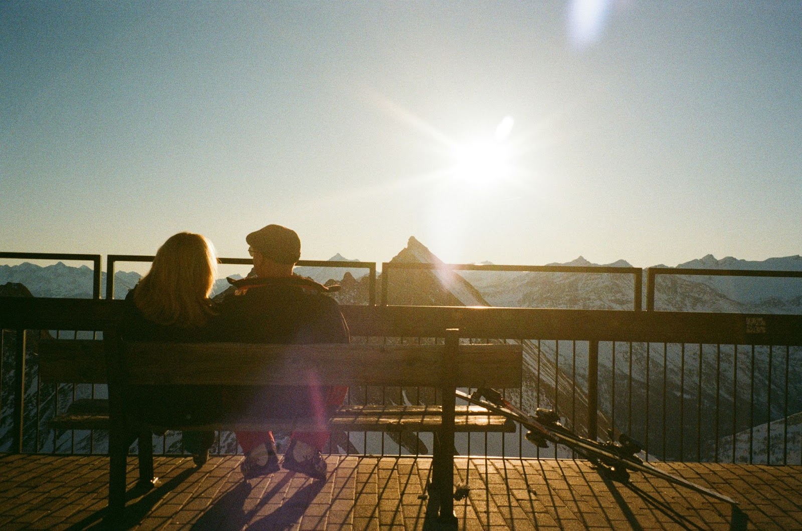 A man and woman sitting on a bench.