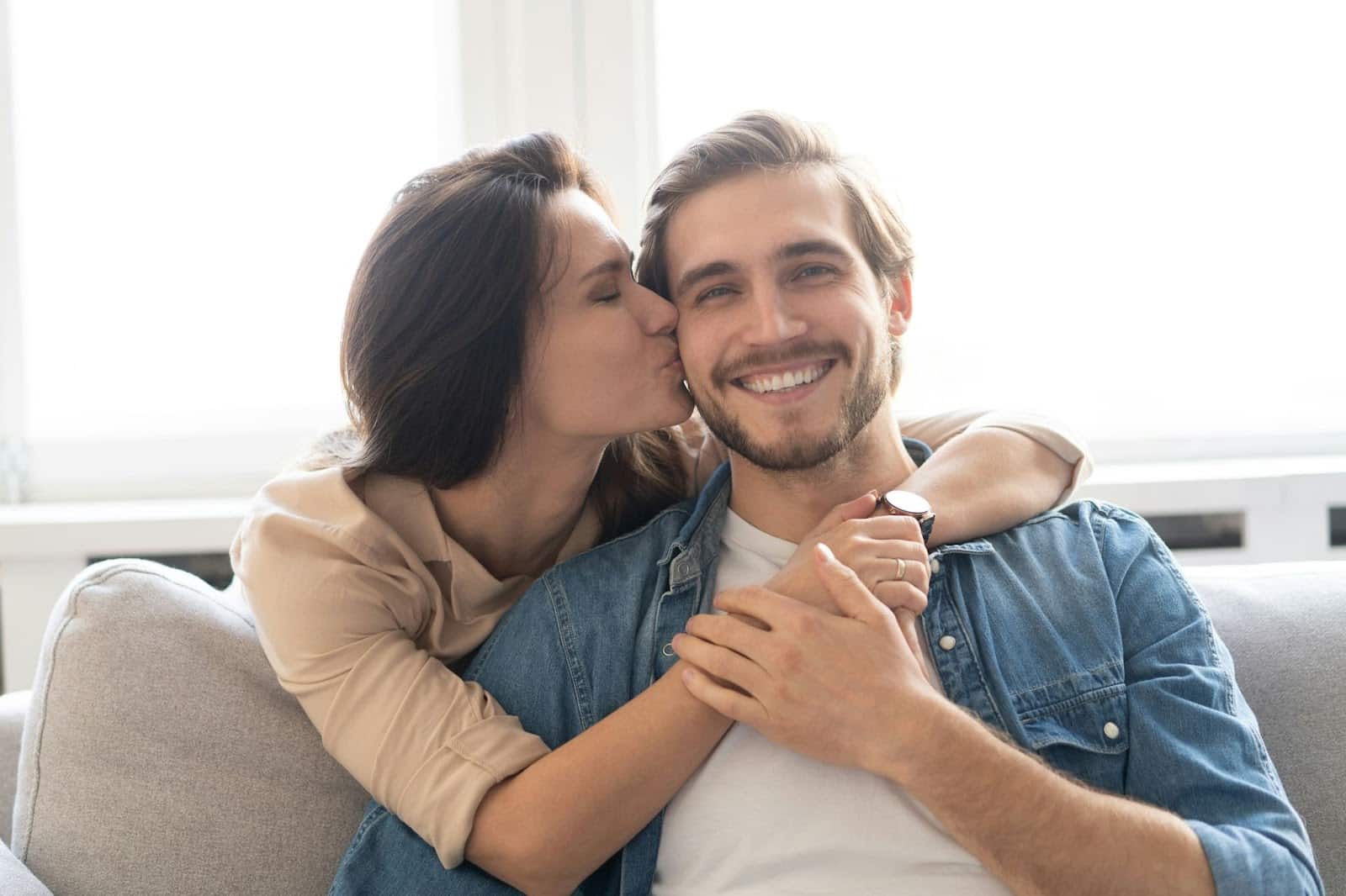 A woman kissing a man’s cheek.