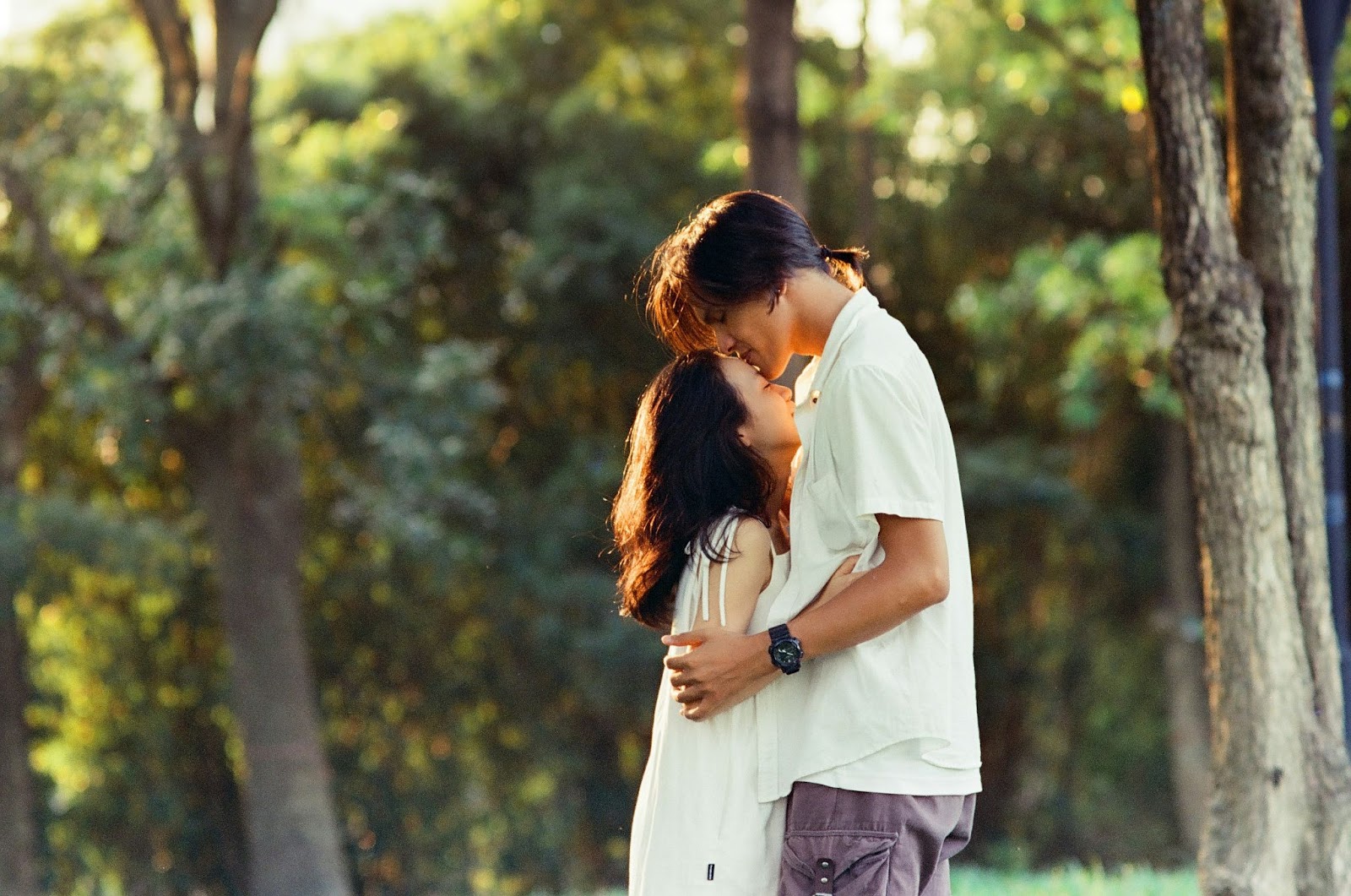 A man kissing a woman’s forehead.