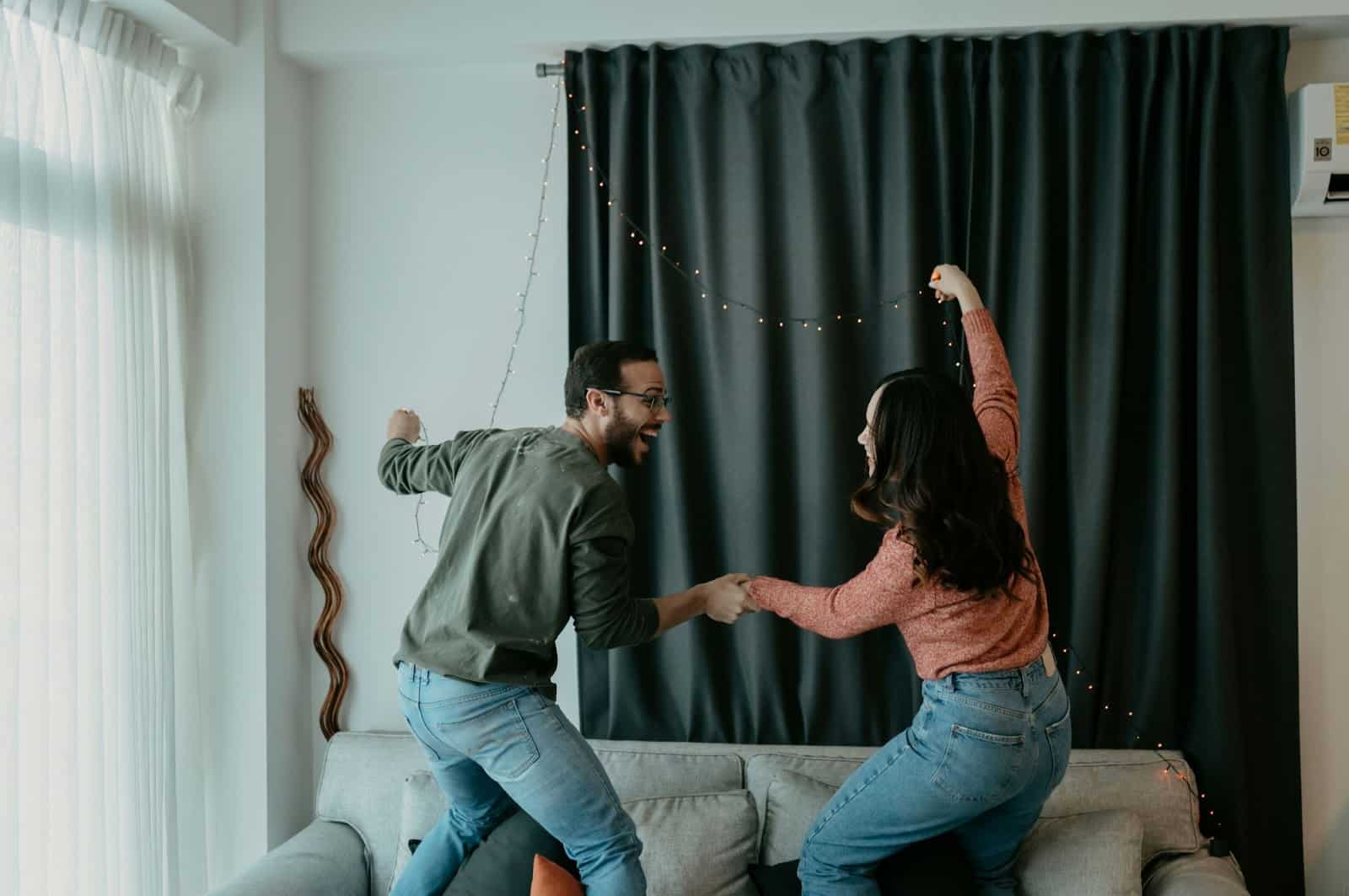 A man and woman dancing at the living room.