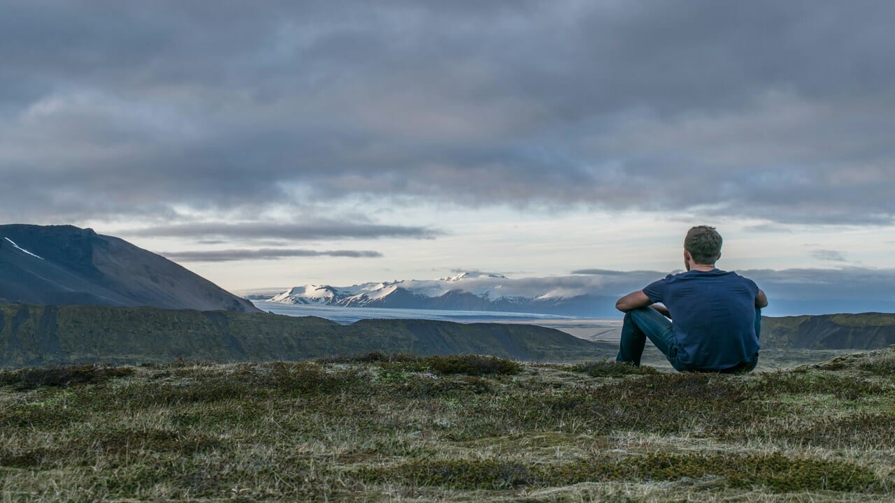 A man sitting alone on a mountain.