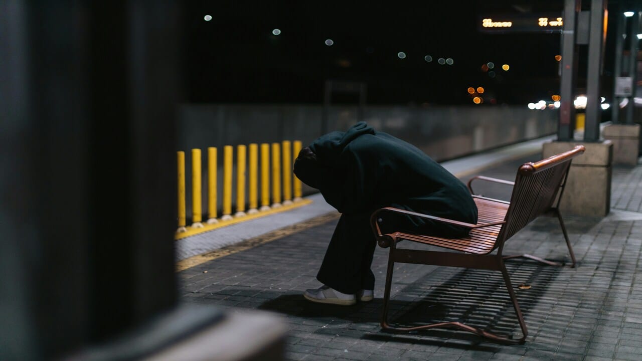 A man looking frustrated on a bench.