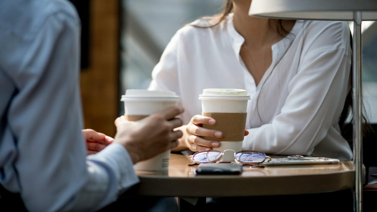 A couple talking at a cafe.