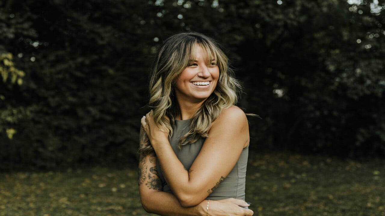 A woman smiling outdoors.