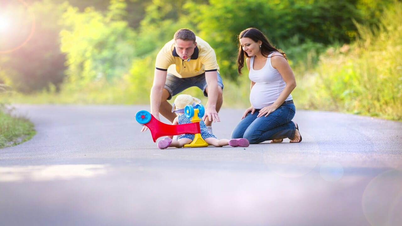 Parents helping their kid stand up.