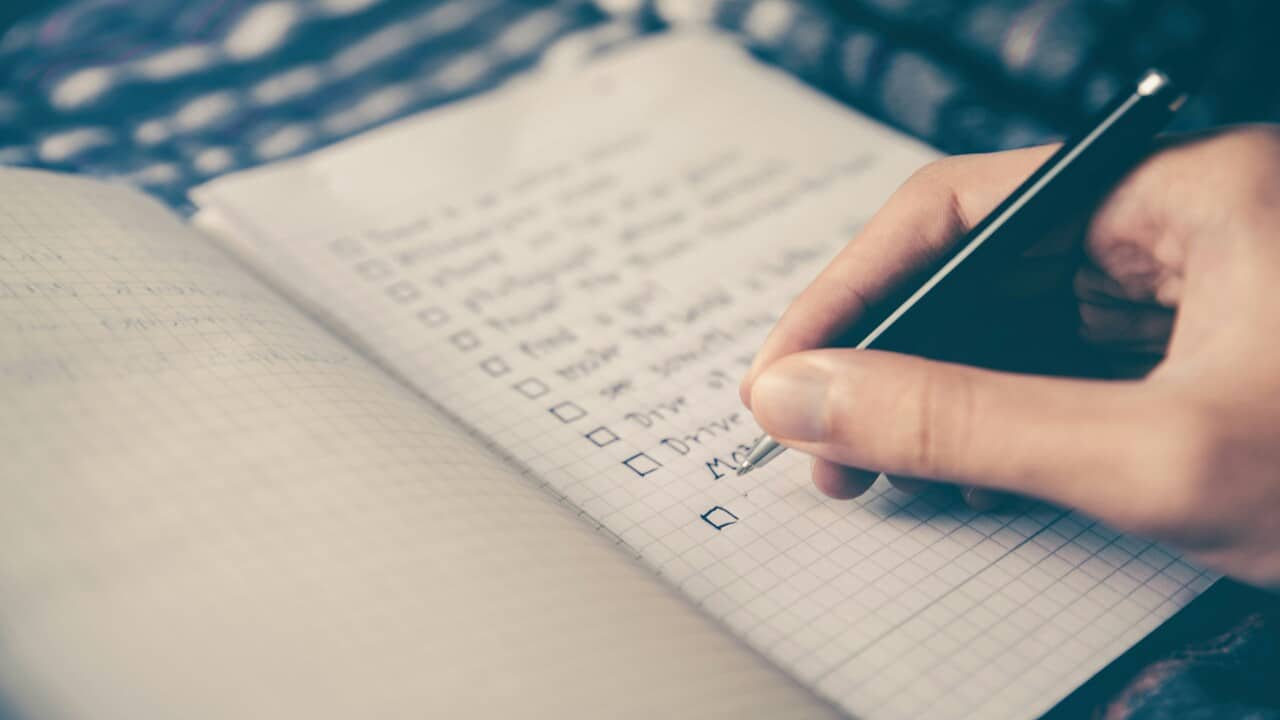 A person writing on a check list.